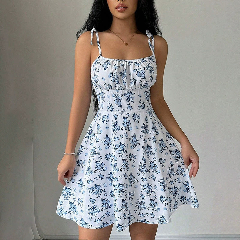 Woman wearing a white floral dress against a plain background