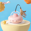 Pink cat-shaped toy with a transparent dome on a yellow stand against a blue background