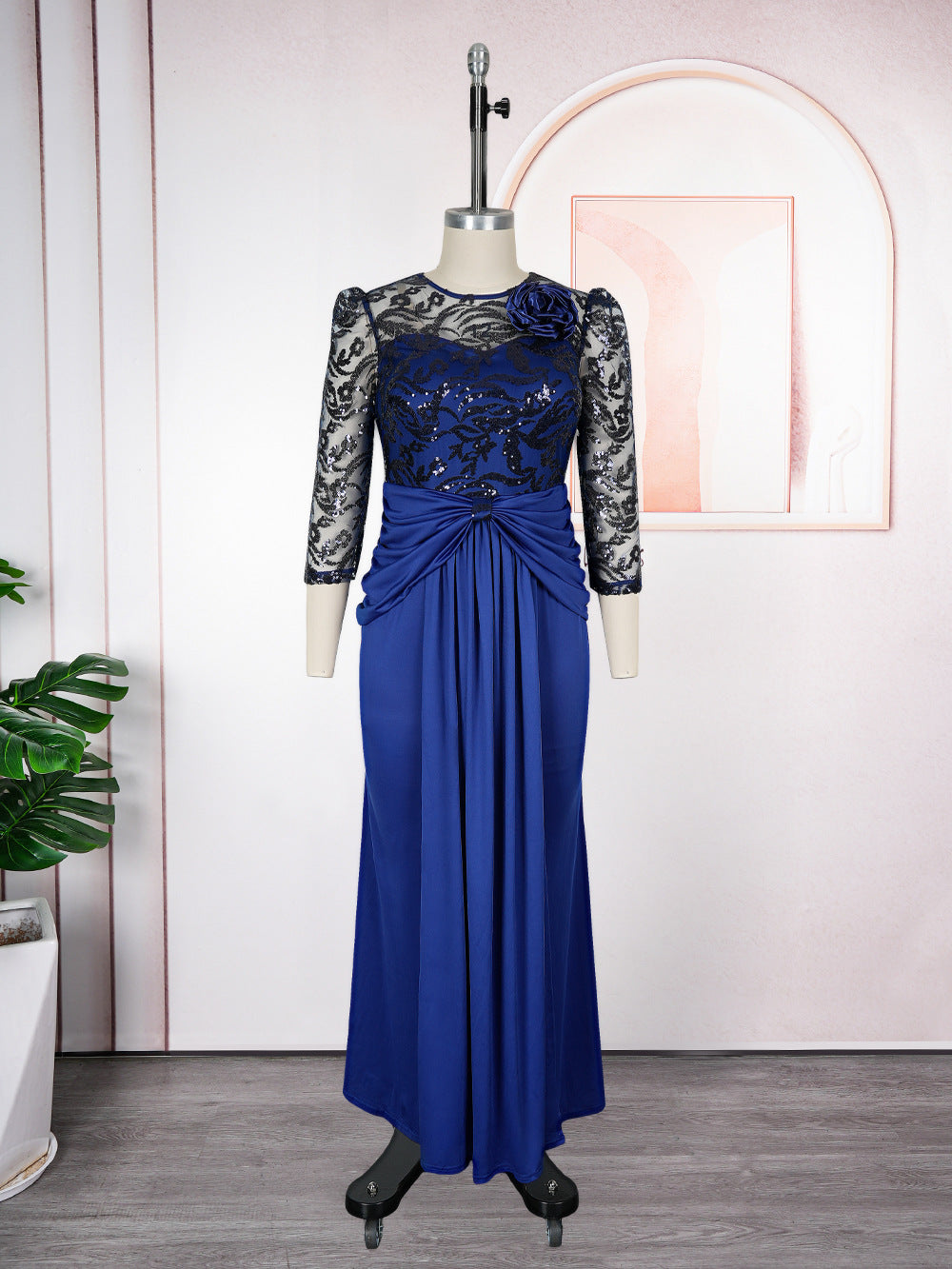Blue evening gown with lace sleeves on a mannequin against a neutral background