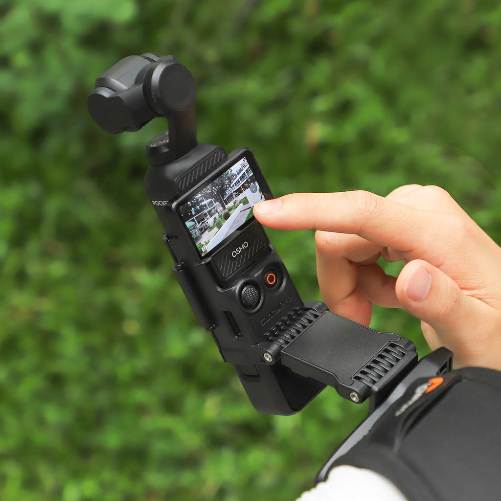 Close-up of a person's hand adjusting a black SUNNYLIFE rotatable backpack clip mount holding a DJI Pocket 3 stabilizer camera.