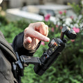 Person using a SUNNYLIFE hands-free backpack clip mount with a DJI Pocket 3 camera stabilizer outdoors.