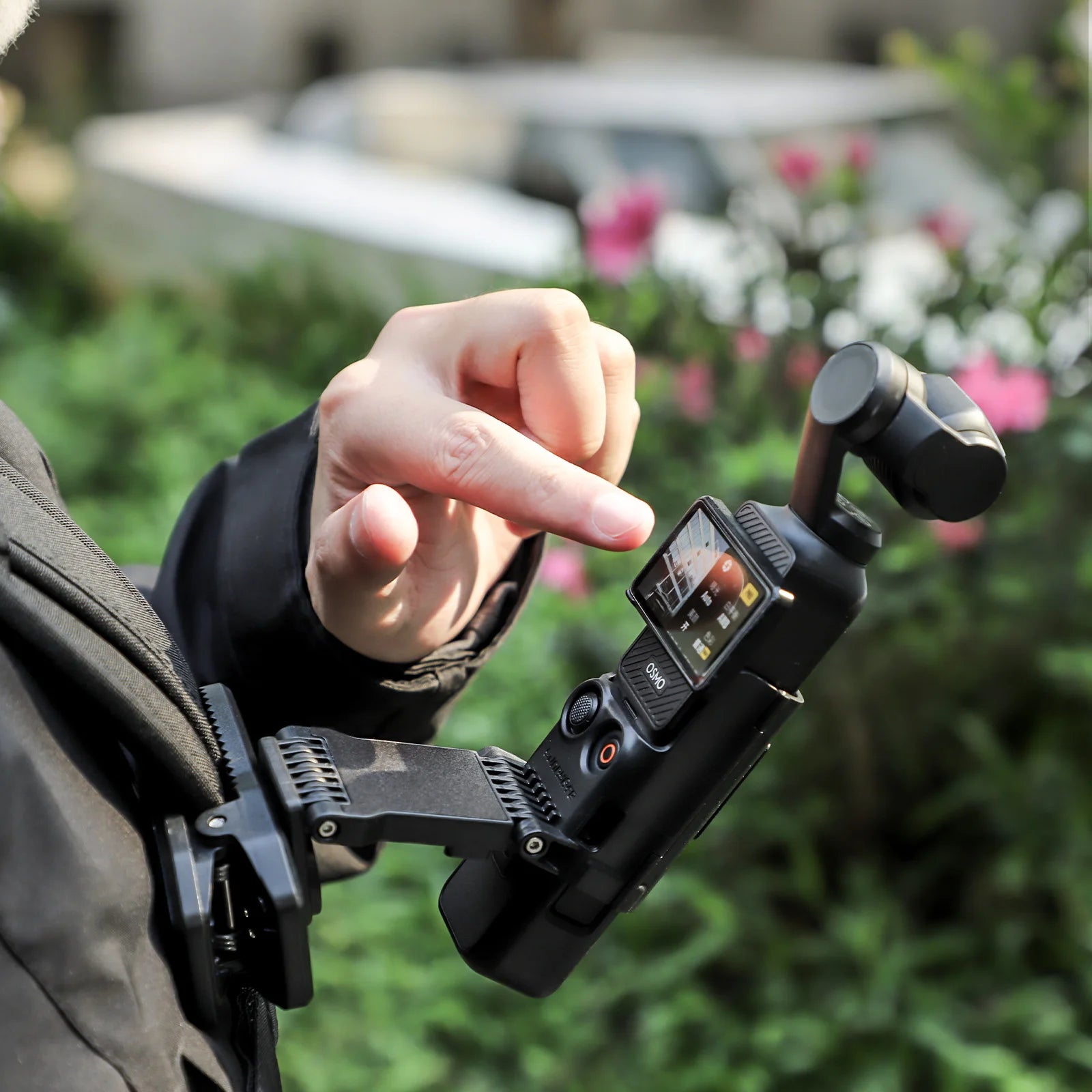 Person using a SUNNYLIFE hands-free backpack clip mount with a DJI Pocket 3 camera stabilizer outdoors.