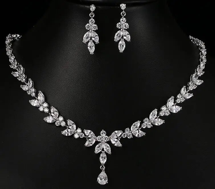 Silver necklace and earrings set on a black background