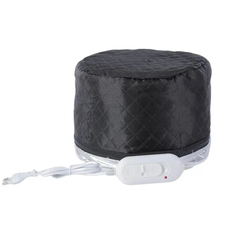 A black quilted electric heated hair conditioning cap shown from the side with its white zipper trim and attached white wired digital temperature remote control.