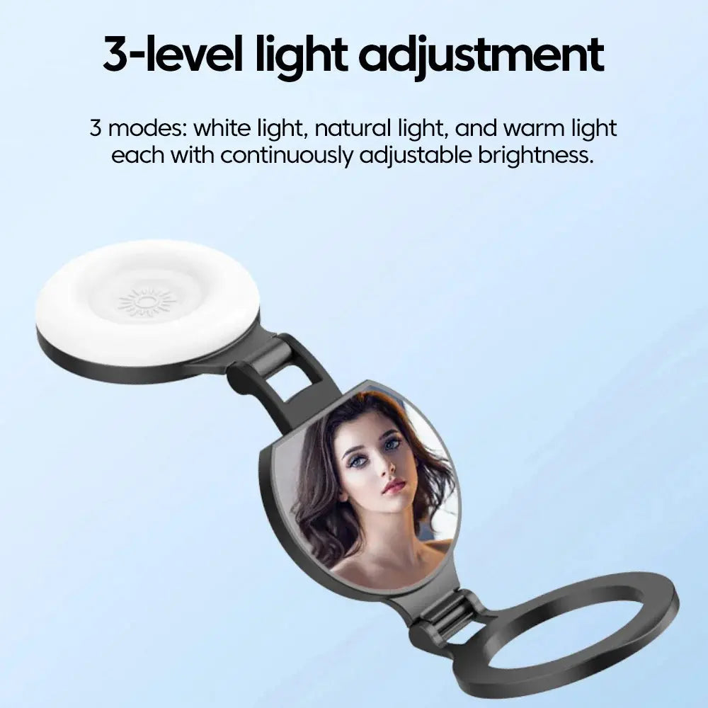 A MagSafe magnetic selfie light with a round lamp head and attached mirror, showing text overlay: "3-level light adjustment" and "3 modes: white light, natural light, and warm light each with continuously adjustable brightness" on a light blue background.