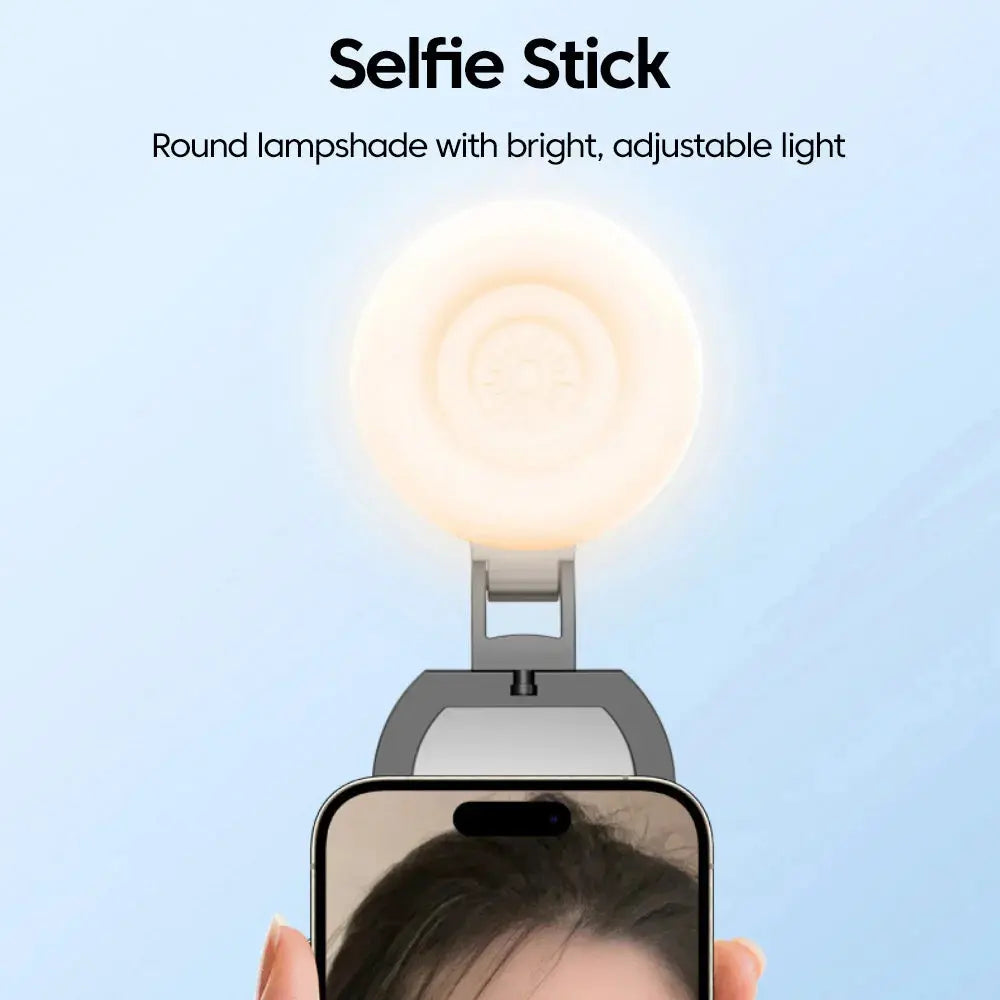 A MagSafe magnetic selfie light featuring a round lamp head, shown attached to a smartphone, with "Selfie Stick" and "Round lampshade with bright, adjustable light" text overlay on a light blue background.