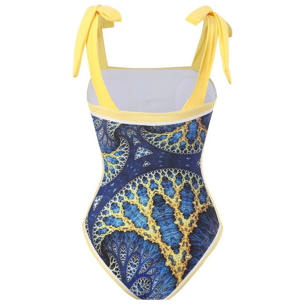 One-piece swimsuit with blue and gold pattern and yellow straps on a white background