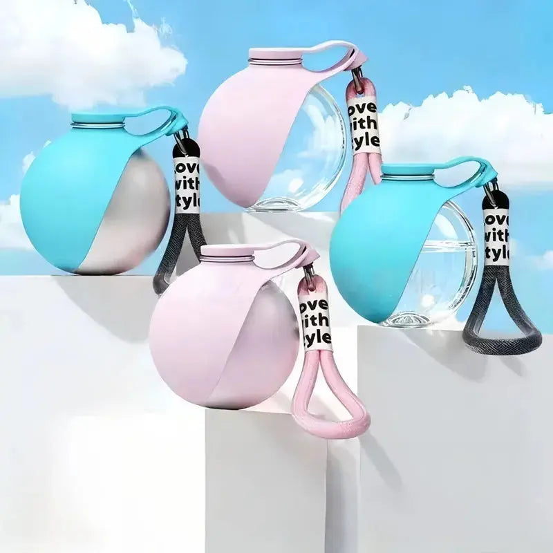 A group of stainless steel portable dog water bottles in teal and pink, featuring pull-up silicone bowls and "love with style" carry straps, displayed against a bright blue sky background.