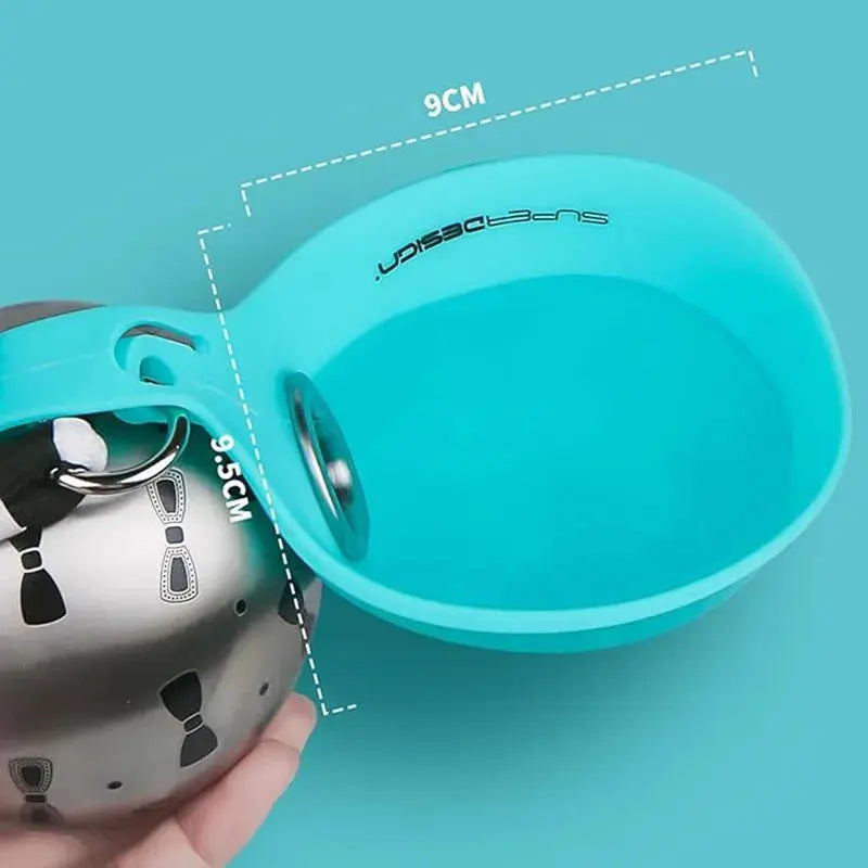Close-up view of the teal silicone bowl on the stainless steel portable dog water bottle, with overlay graphics highlighting its 9cm width and 9.5cm depth for easy portion measuring.