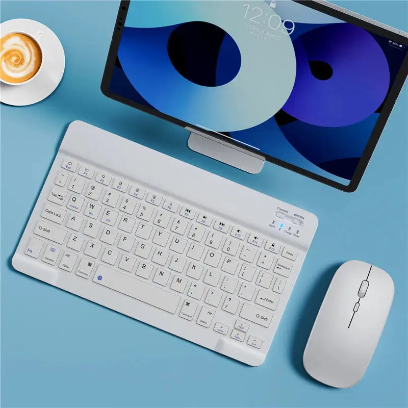 Keyboard and mouse set on a blue surface with a tablet in the background