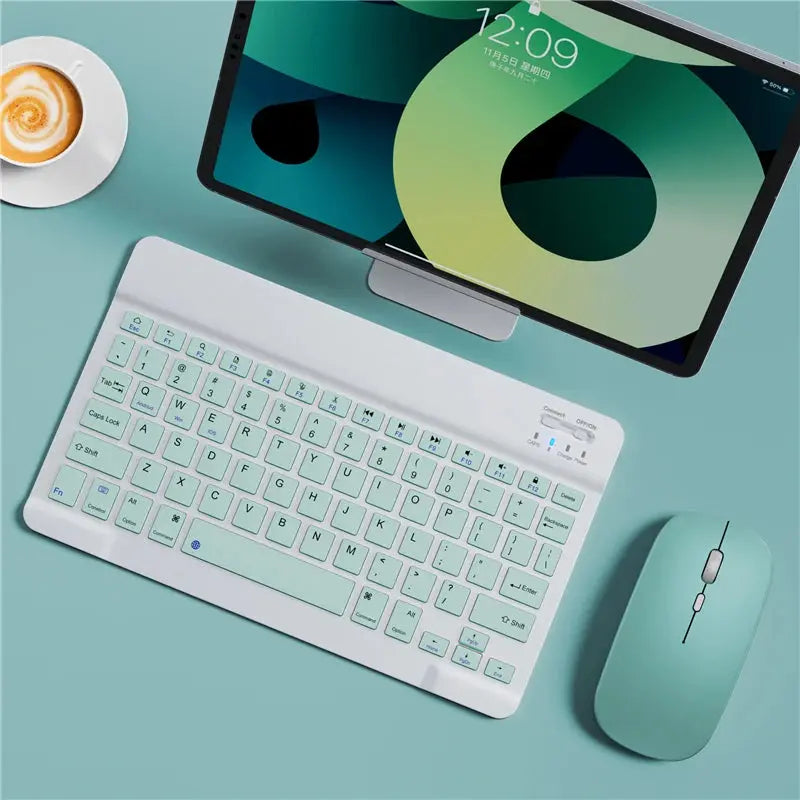 Tablet with keyboard and mouse on a teal surface
