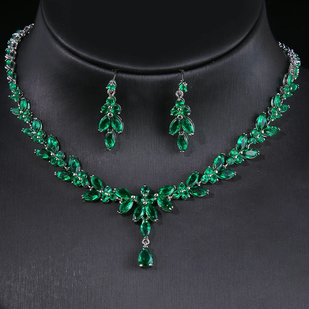 Green gemstone necklace and earrings set on a black background