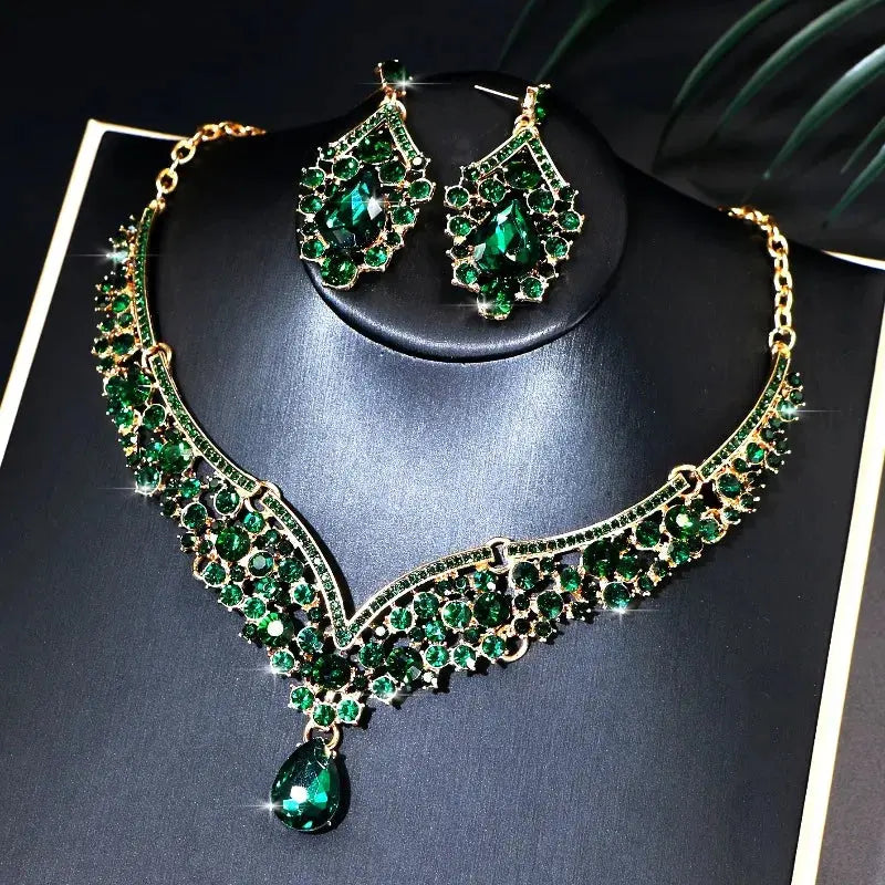 Jewelry set with necklace and earrings featuring green gemstones on a dark background