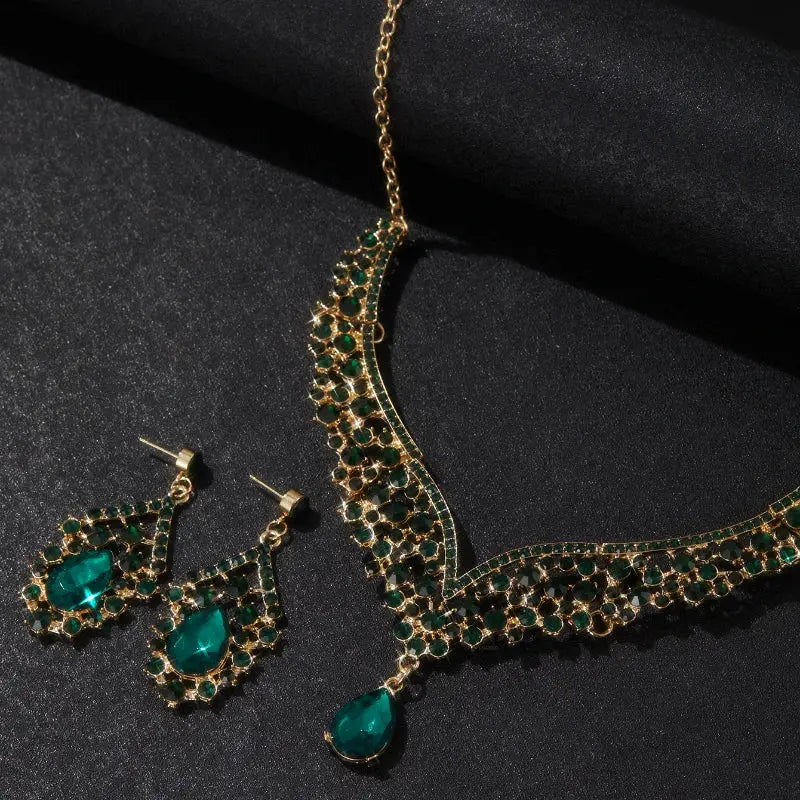 Gold and green jewelry set on a black background