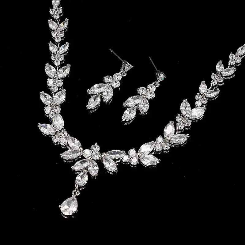 Silver necklace and earrings set on a black background