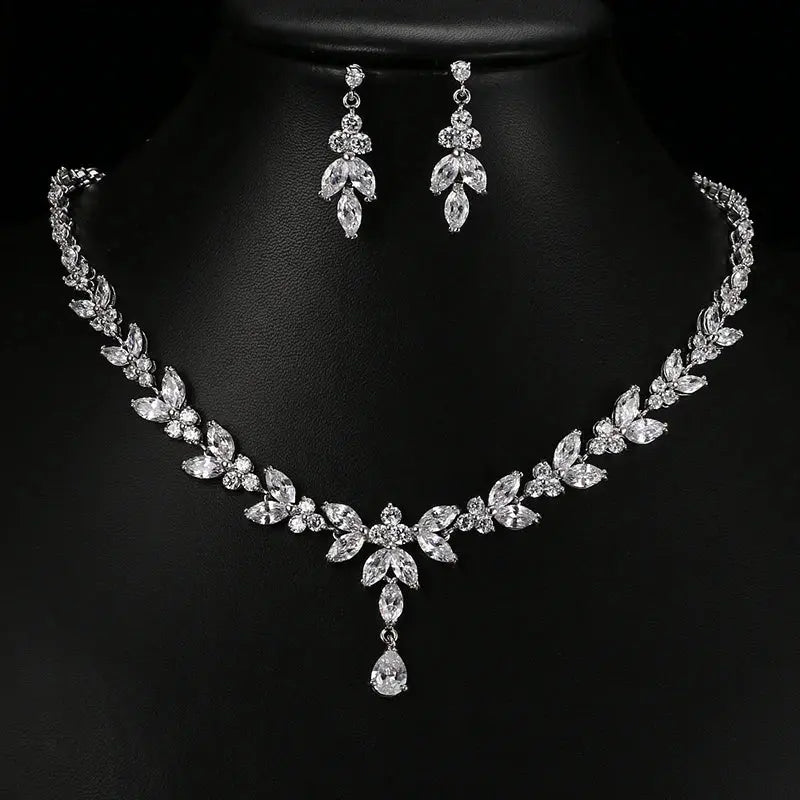 A stunning cubic zirconia bridal necklace and matching stud earrings set displayed on a black background.
