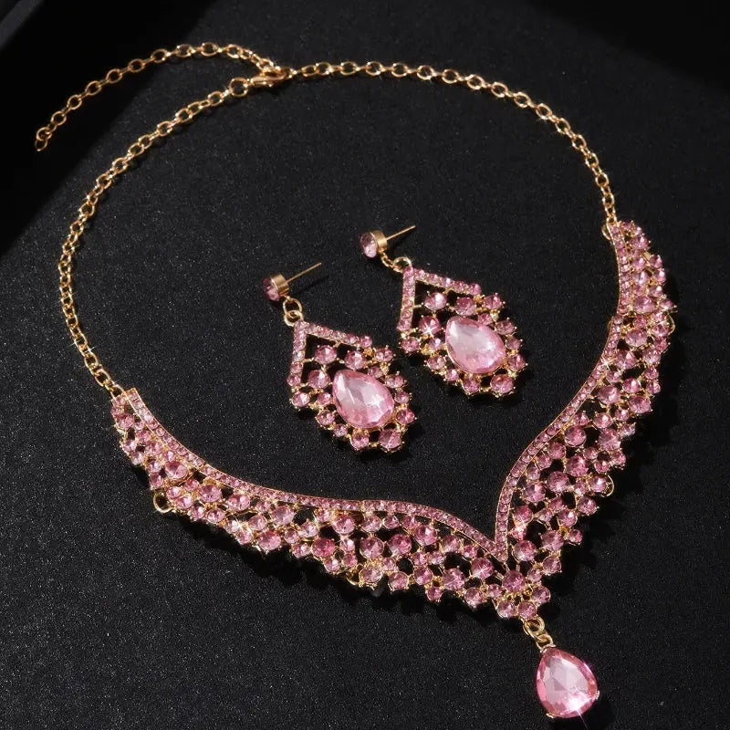 Pink gemstone necklace and earrings on a black background