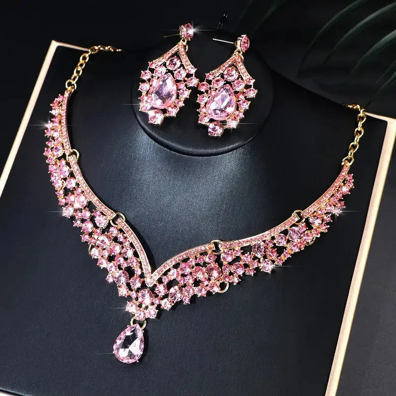 Pink gemstone necklace and earrings on a black background