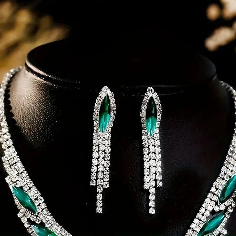 Detailed shot of the marquise-cut emerald stones set in a shimmering silver-toned frame for a high-glamour look.
