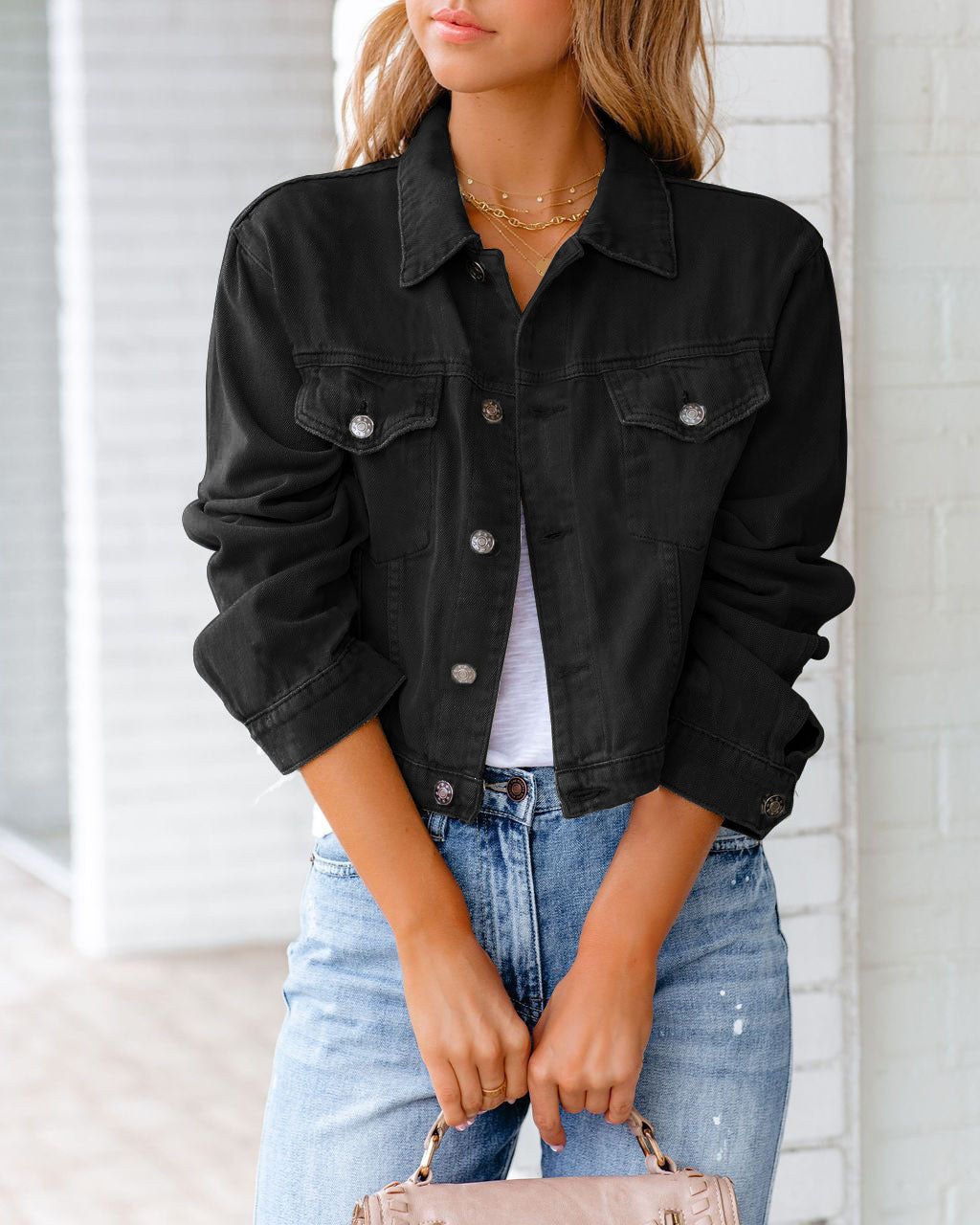 Young woman wearing the casual short denim jacket in black with lapel collar and button closure