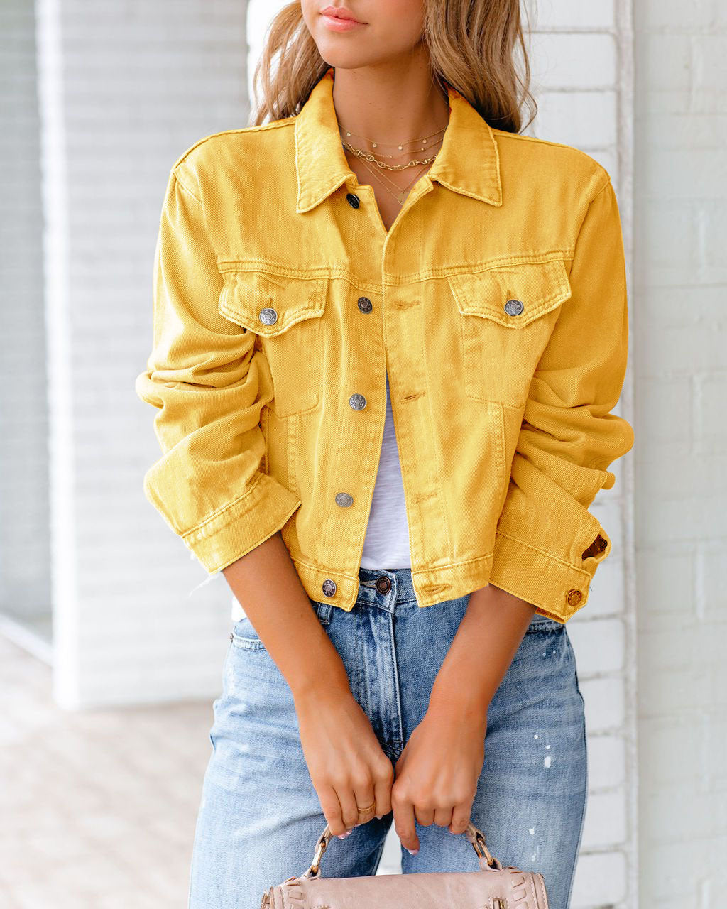 Young woman wearing the casual short denim jacket in yellow with lapel collar and button closure