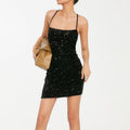 Close-up of sparkling all-over sequin embellishment on women's mini dress